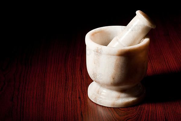 Marble mortar and pestle on dark wood background