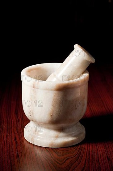 Marble mortar and pestle on dark wood background