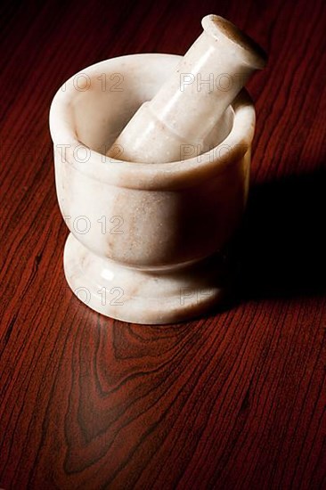 Marble mortar and pestle on dark wood background