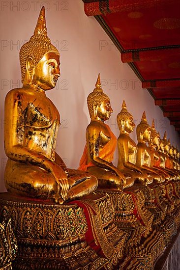 Row of sitting Buddha statues in Buddhist temple Wat Pho