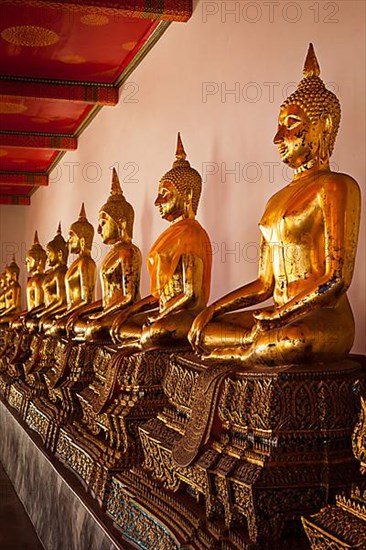 Row of sitting Buddha statues in Buddhist temple Wat Pho