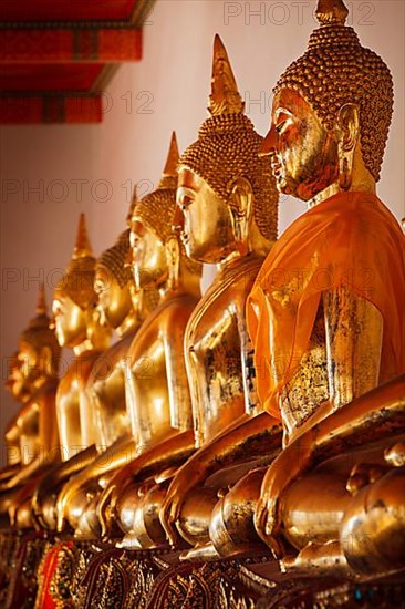 Row of sitting Buddha statues in Buddhist temple Wat Pho