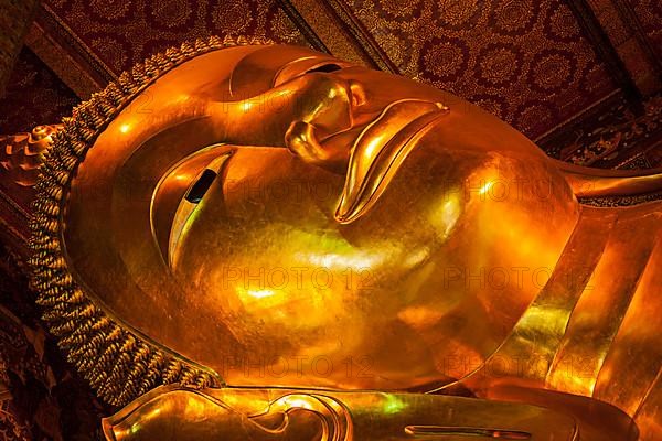 Reclining Buddha gold statue face close up. Wat Pho