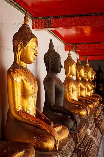 Row of sitting Buddha statues in Buddhist temple Wat Pho