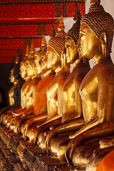 Row of sitting Buddha statues in Buddhist temple Wat Pho