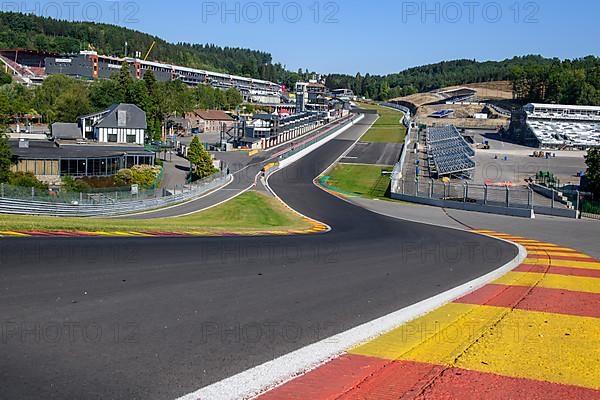 View from 40 metres high hilltop above the steep Raidillon driveway in the foreground to the dangerous Eau Rouge bend in the background of the Spa Francorchamps race track without racing cars