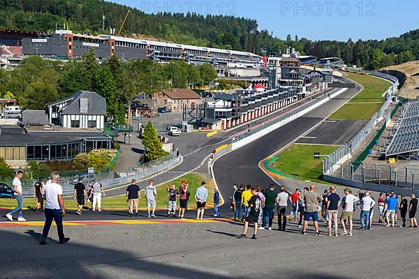 Trackday participants visit dangerous Eau Rouge courage curve get information from guided tour of FIA Formula 1 circuit