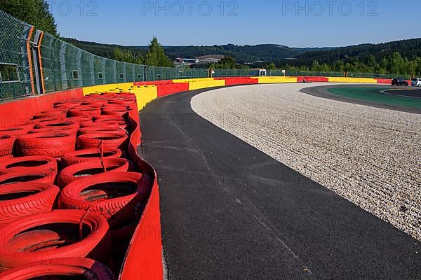 Safety measure for car racing Impact protection red yellow coloured tyre piles next to gravel bed in turn 8 of racetrack for motorsport