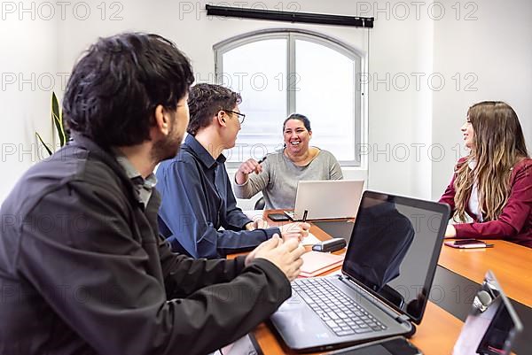 People working on laptops during a meeting in the office