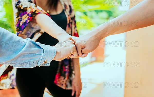 Close up of three friends bumping fists