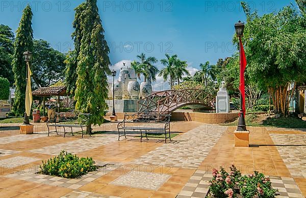 A nice and relaxed park with a wooden bridge over a water fountain