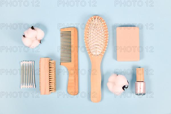 Eco friendly wooden beauty and hygiene products like comb and soap on blue background
