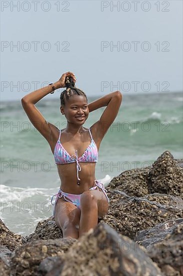 Young dark-skinned woman with bikini on the beach