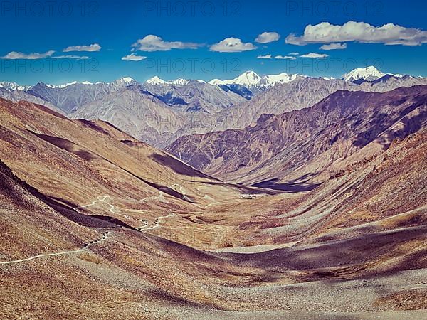 Vintage retro effect filtered hipster style image of Karakoram range and road in valley from Kardung La