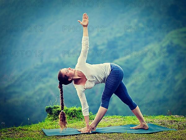 Vintage retro effect hipster style image of woman doing Ashtanga Vinyasa yoga asana Parivrtta trikonasana