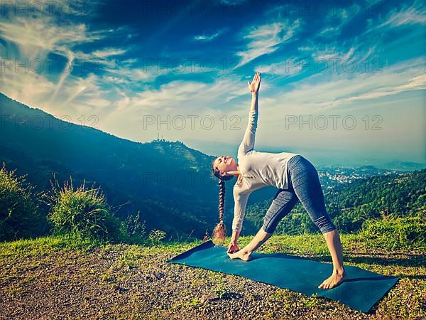 Vintage retro effect hipster style image of woman doing Ashtanga Vinyasa yoga asana Utthita trikonasana