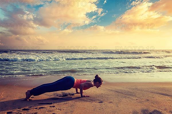 Vintage retro hipster effect image of woman practices Ashtanga Vinyasa yoga