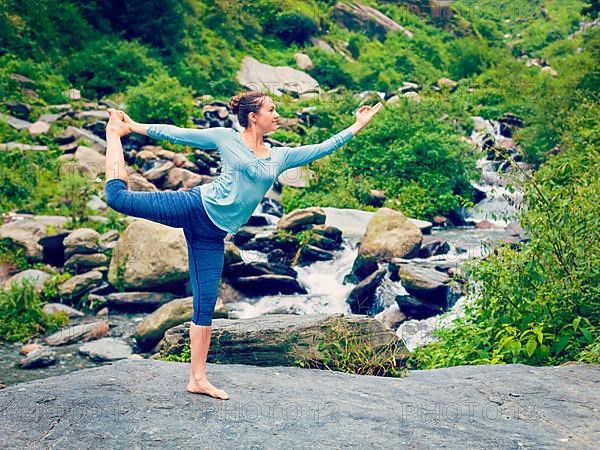 Vintage retro effect hipster style image of woman doing yoga asana Natarajasana