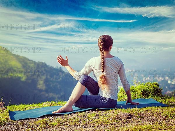 Vintage retro effect hipster style image of sporty fit woman practices yoga asana Parivrtta Marichyasana