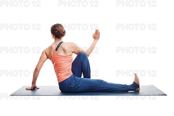 Beautiful sporty fit yogini woman practices yoga asana Marichyasana C