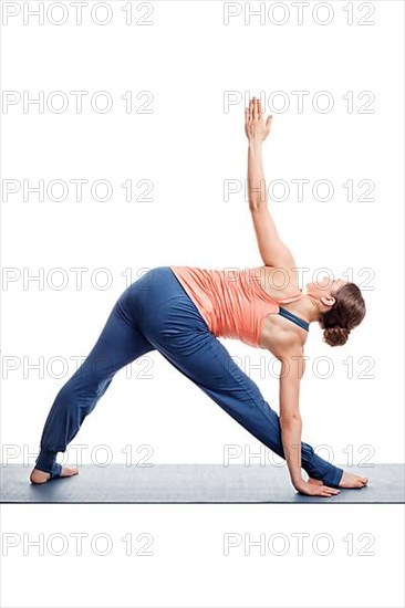 Sporty fit woman practices Ashtanga Vinyasa yoga asana utthita trikonasana