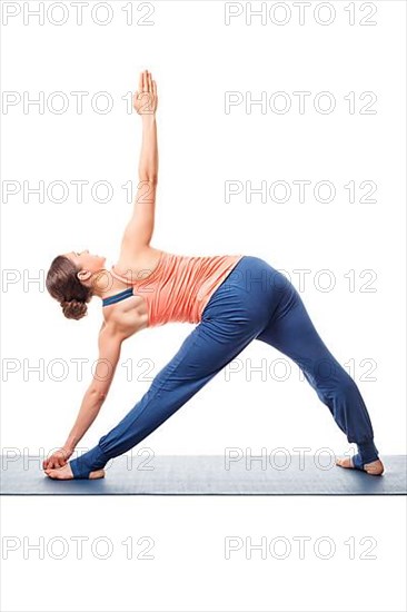 Young fit woman doing Ashtanga Vinyasa Yoga asana utthita trikonasana