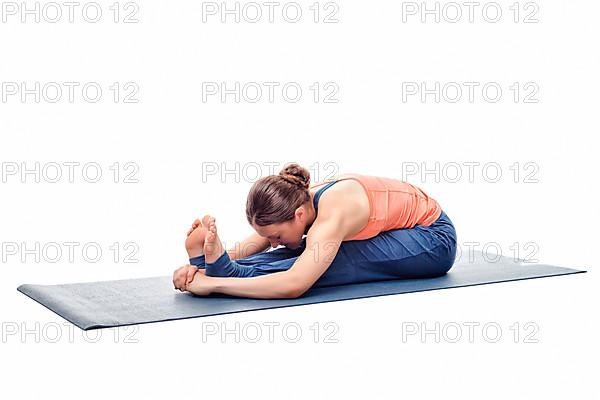 Sporty fit woman practices Ashtanga Vinyasa yoga back bending asana Paschimottanasana