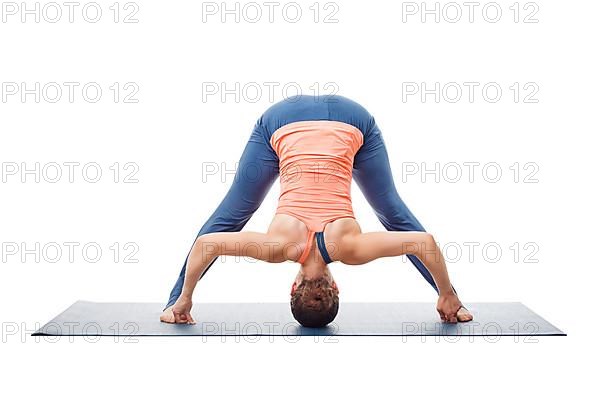 Beautiful sporty fit woman practices Ashtanga Vinyasa yoga asana Prasarita padottanasana D