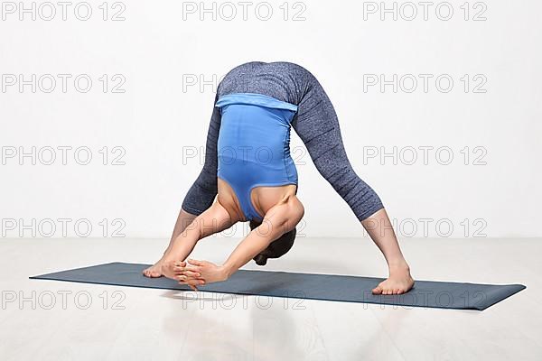 Beautiful sporty fit woman practices Ashtanga Vinyasa yoga asana Prasarita padottanasana C