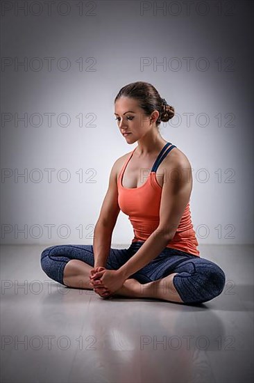Beautiful sporty fit woman practices yoga asana Baddha konasana
