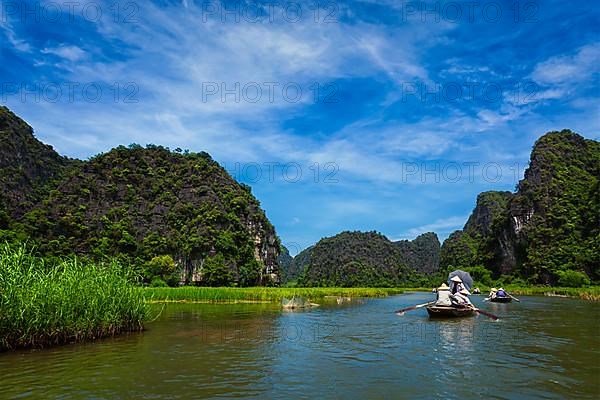 Tourists on boats in Tam Coc-Bich Dong Ngo Dong river in popular tourist destination near Ninh Binh