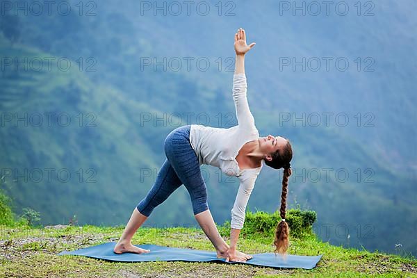 Woman doing Ashtanga Vinyasa yoga asana Parivrtta trikonasana