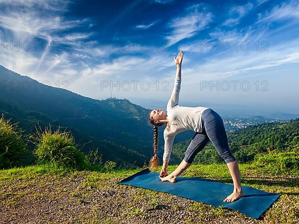 Woman doing Ashtanga Vinyasa yoga asana Utthita trikonasana