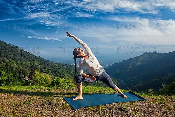 Sporty fit woman practices yoga asana Utthita Parsvakonasana