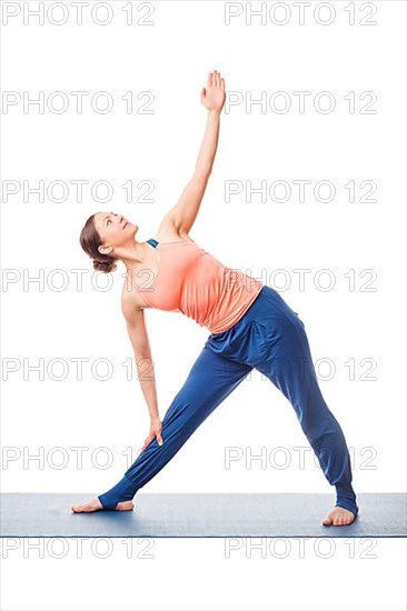 Beautiful sporty fit woman practices yoga asana utthita trikonasana