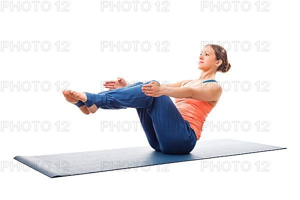 Beautiful sporty fit woman doing Ashtanga Vinyasa yoga asana Paripurna navasana