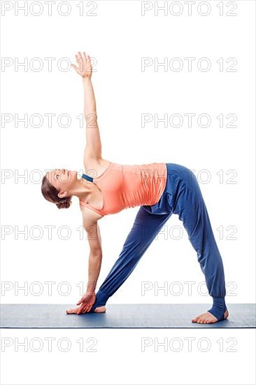 Beautiful sporty fit woman practices yoga asana utthita trikonasana