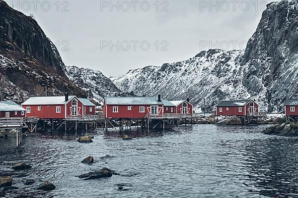 Nusfjord authentic traditional fishing village with traditional red rorbu houses in winter in Norwegian fjord. Lofoten islands