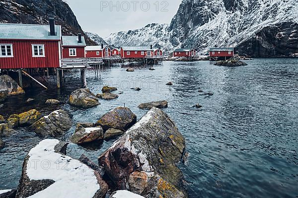 Nusfjord authentic traditional fishing village with traditional red rorbu houses in winter in Norwegian fjord. Lofoten islands