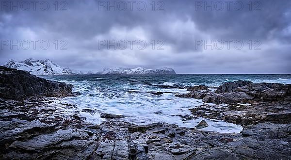 Panorama of waves of Norwegian sea crushing at rocky coast in fjord. Vikten