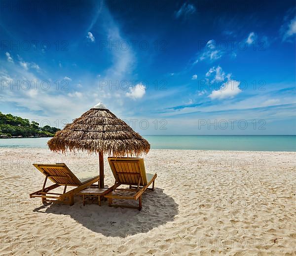 Two beach lounge chairs under tent on beach. Sihanoukville