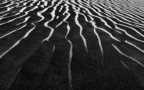 Shadow and light dunes sand close up on sunrise. Black and white version