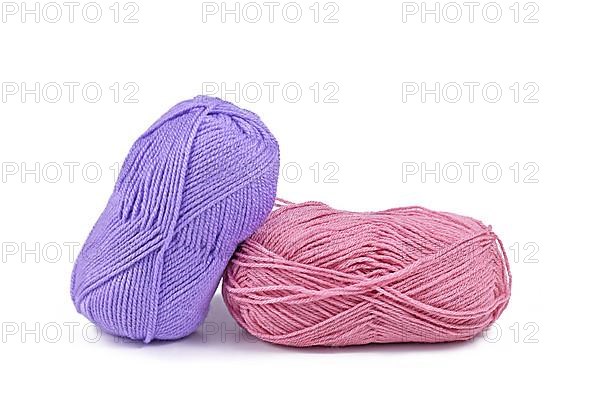 Balls of pink and purple wool on white background