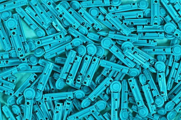 Many blue disposable diabetes lancets used to draw blood for testing