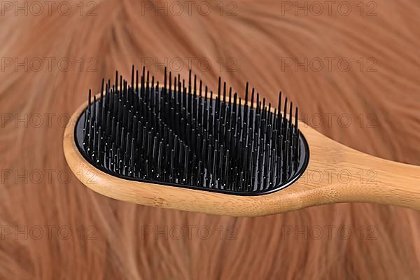 Detangler hair brush with different bristle lengths to separate hair instead of pulling it down
