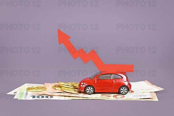 Red car with rising arrow and money coins and bills