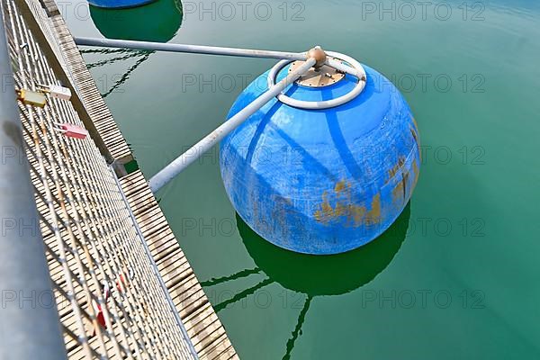 Blue round float used to hold floating bridge above water