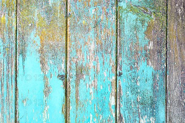 Vertical wooden planks background with teal blue and yellow colored old weathered planks with chipped paint