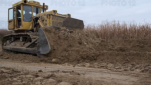 Bulldozer removes dam in the delta Danube river. Close up