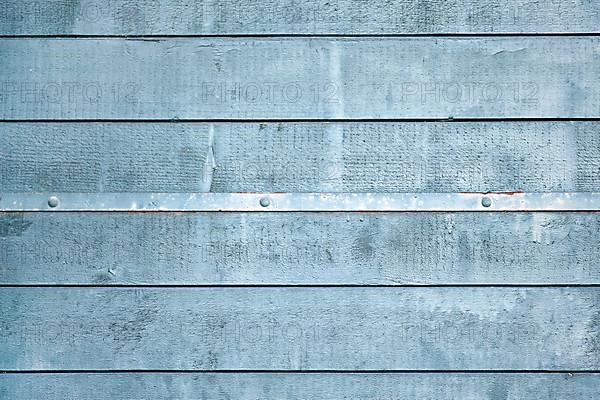 Gray blue wooden background with horizontal old planks and metal strip with nails